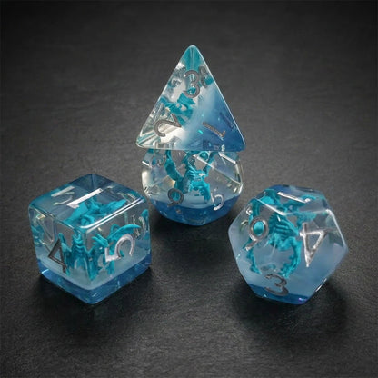 Azure Dragonling close-up of four clear resin embedded DND dice with blue dragon figures on a dark background.