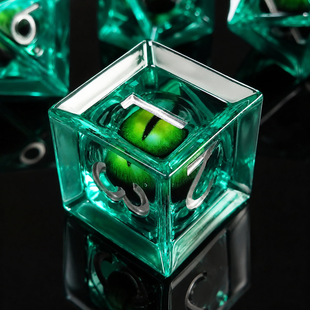 Emerald Dragon Eye close-up of a green liquid core D6 DND die with a green dragon eye and silver numbers on a black reflective surface.