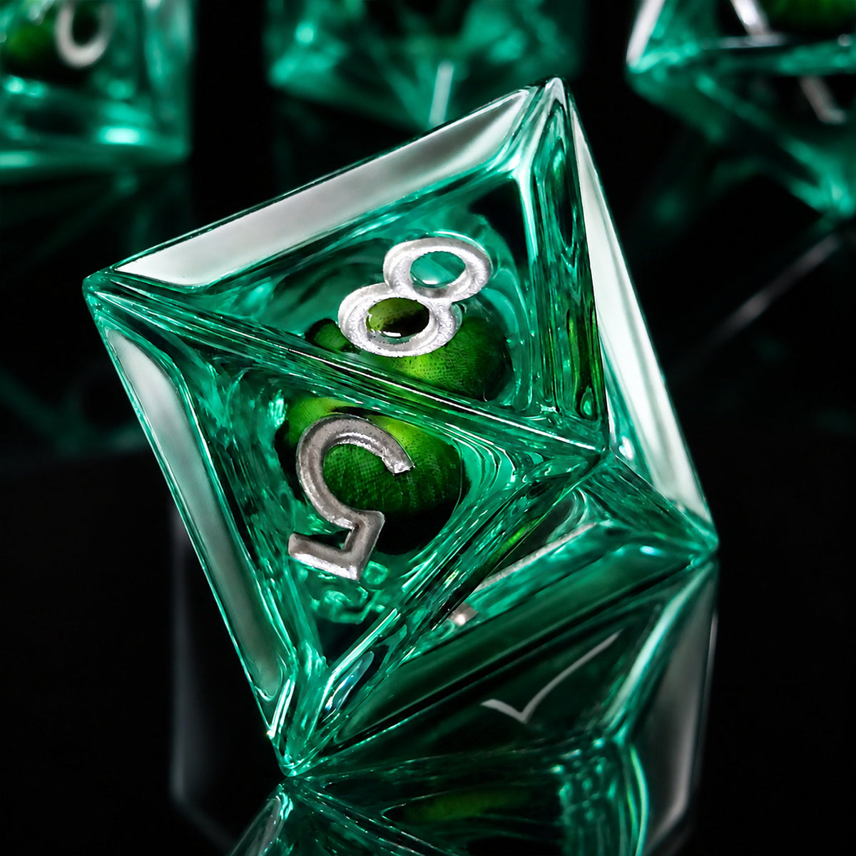 Emerald Dragon Eye close-up of a green liquid core D8 DND die with a green dragon eye and silver numbers on a black reflective surface.