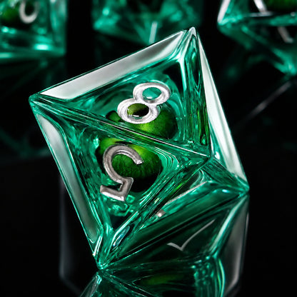 Emerald Dragon Eye close-up of a green liquid core D8 DND die with a green dragon eye and silver numbers on a black reflective surface.