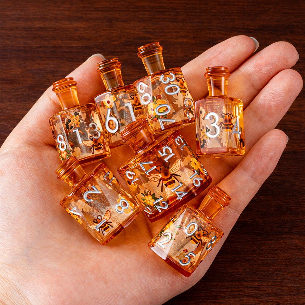 Honeyed Vial 7-piece amber resin liquid core DND dice set with bee and flower motifs held in hand.