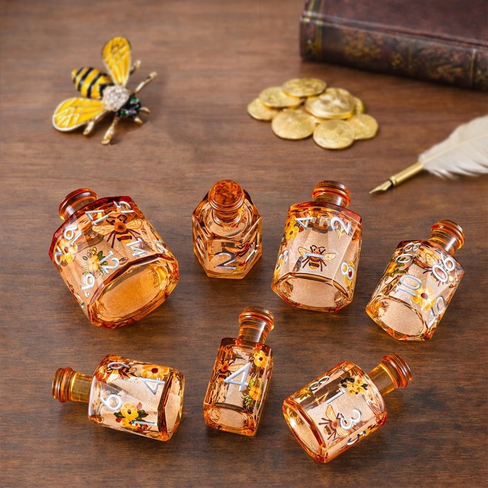 Honeyed Vial 7-piece amber resin liquid core DND dice set with bee and flower motifs in a tabletop scene with bee ornament and gold coins.