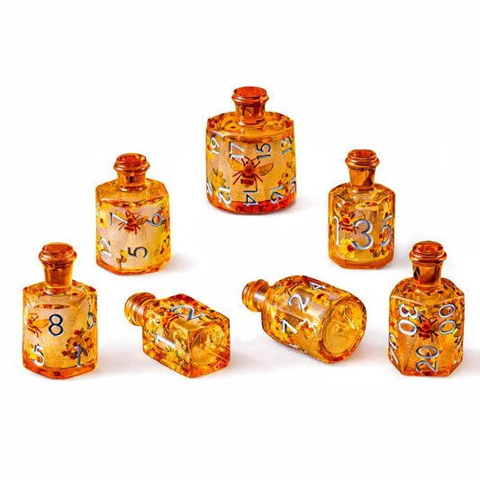 Honeyed Vial 7-piece amber resin liquid core DND dice set with bee and flower motifs on white background.