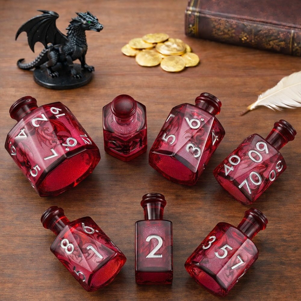 Infernal Dragon 7-piece red resin liquid core DND dice set with red dragon motifs in a tabletop scene with dragon figurine and gold coins.