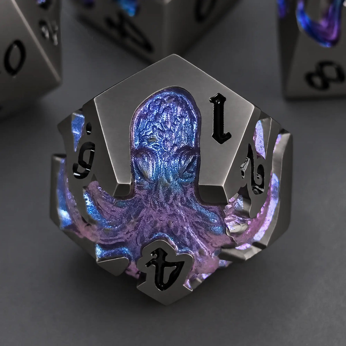 Nightfall Kraken gunmetal D12 with blue-purple chameleon pigment kraken design and black numbers.