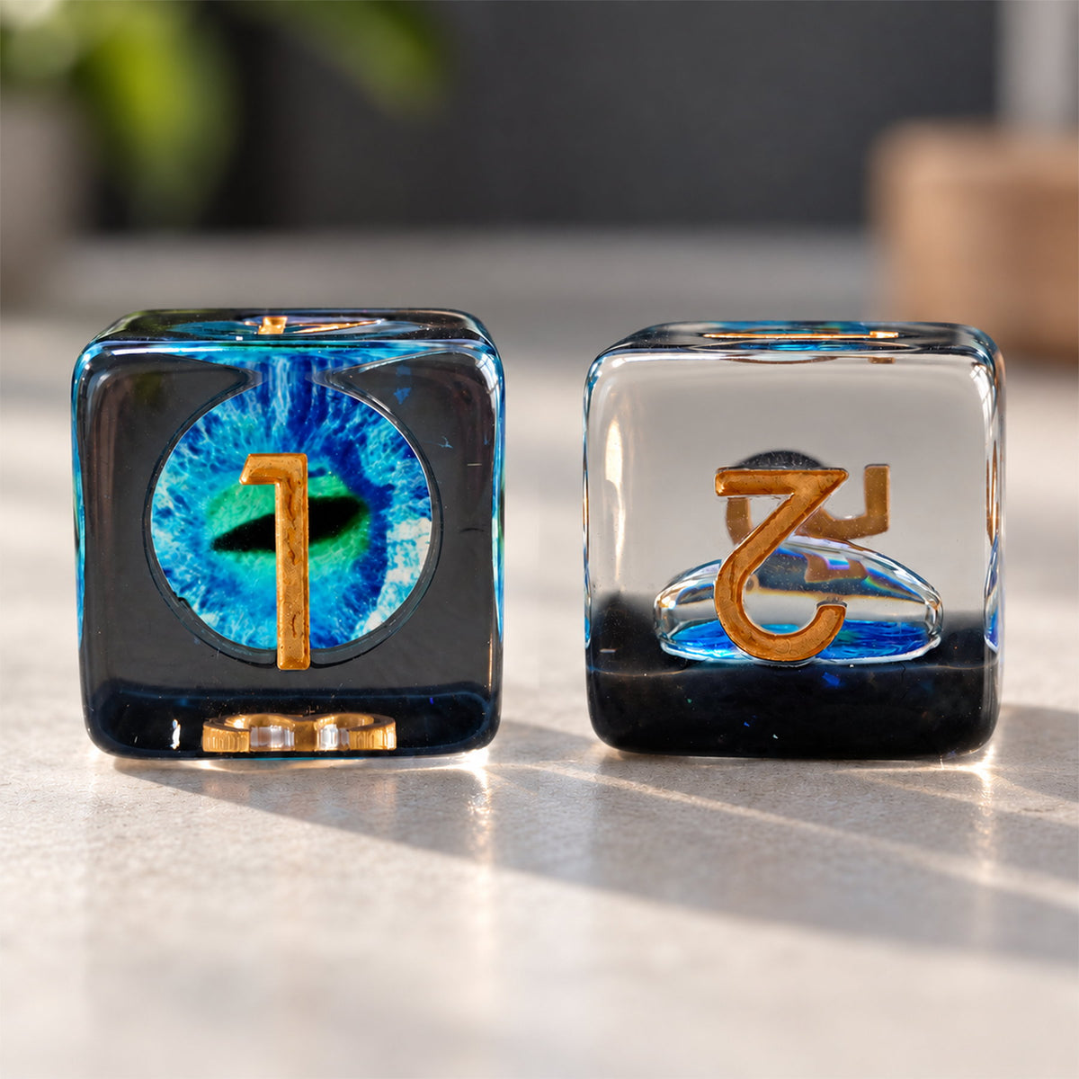 Tidal Dragon Eye D6 black resin DND die shown from two angles with blue-green dragon eye and gold numbers.
